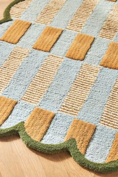 a close up of a rug on the floor with different colors and shapes in it