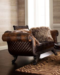 a brown leather chair sitting on top of a wooden floor next to a zebra print rug