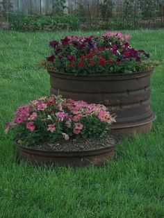 two flower pots sitting in the grass near each other