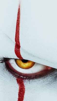the eye of a demonic looking person with red streaks on it's irises