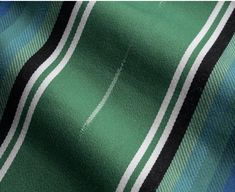 a green and blue plaid fabric with white stripes on it's edges, close up