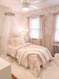 a bedroom with a white bed and pink curtains