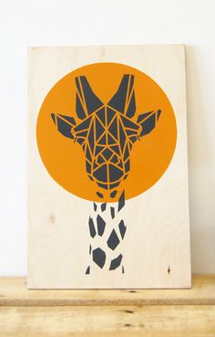 a giraffe is shown in an orange circle on a wooden block with black dots