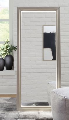 a living room with white brick walls and black vases