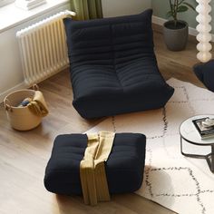 a living room filled with furniture and a rug on top of a hard wood floor