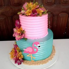 a pink and blue cake with flowers on top
