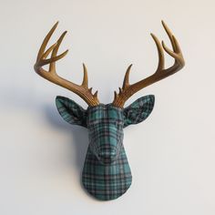 a deer head mounted on the wall with tartan plaid fabric covering it's antlers