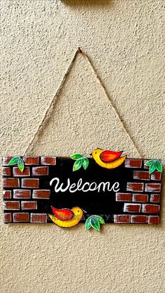 a welcome sign hanging from the side of a brick wall