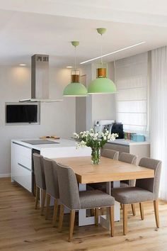 a dining room table and chairs in front of a tv