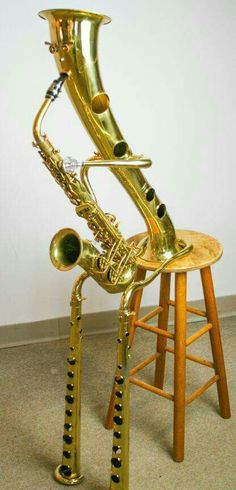 a gold saxophone sitting on top of a wooden stool