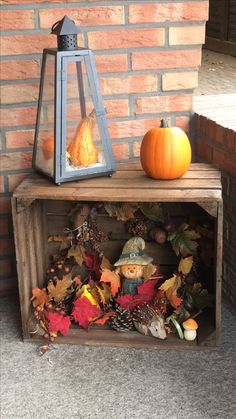 a small wooden box filled with fall leaves and a pumpkin sitting on top of it