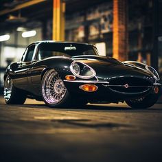 a black sports car parked in front of a building with lights on it's headlight