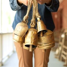 a person holding two bells with rope attached to them