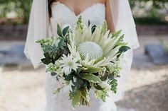 a bride holding a bouquet of flowers in her hand