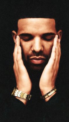 a man holding his hands to his face while wearing gold bracelets on his wrist