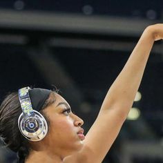 a female basketball player with headphones on and her arm up in the air,