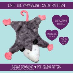 an elephant stuffed animal laying on top of a heart shaped pillow with the words, opie the opossun lovey pattern