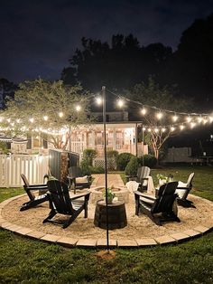 an outdoor patio with lights and lawn chairs in the middle of the yard at night
