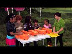 several children standing around a table with orange boxes on it