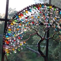 a tree made out of glass beads in front of a window