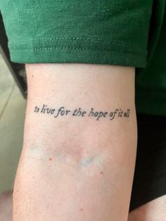 a person with a tattoo on their arm that says to live for the hope of it all