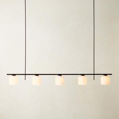 four lights are hanging from the ceiling in a room with white walls and flooring