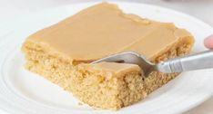 a piece of cake with peanut butter frosting on it being held by a fork