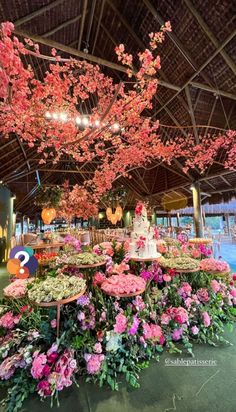 a table with flowers and cake on it in a room that has a ceiling made of rafters