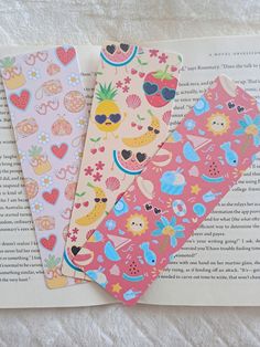 three bookmarks sitting on top of an open book