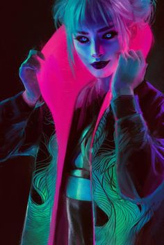 a woman with blonde hair and blue eyes is posing for a photo in neon light