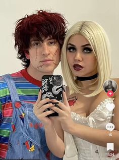 two people dressed up as zombies and one is holding a cell phone with her mouth open