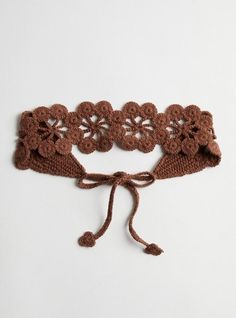 a crocheted headband with flowers on it