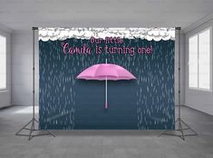 a pink umbrella sitting in the middle of a room next to a wall with words on it