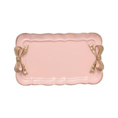 a pink and gold serving tray with bow handles