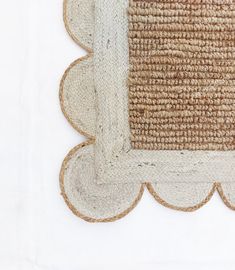 a close up of a rug with a white border on the bottom and tan trim around the edges