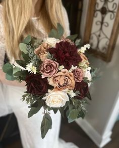 a woman holding a bouquet of flowers in her hands