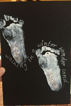 someone is holding up a card with two footprints