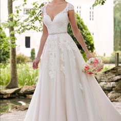 a woman in a wedding dress is walking down the street with her hand on her hip