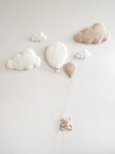 there is a balloon with some clouds on it and two teddy bears hanging from the strings