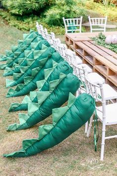 there are many green umbrellas lined up on the table with white chairs and tables