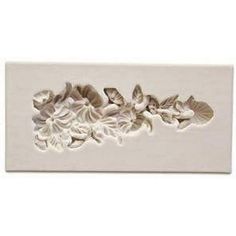 a white tile with flowers and leaves on it