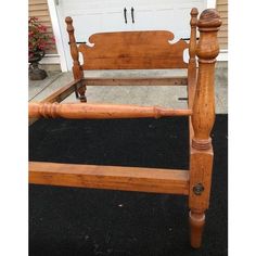 a wooden bed frame sitting on top of a black carpeted floor next to a garage