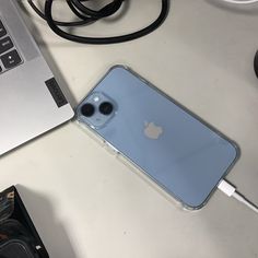 an iphone is plugged in to a charger on a desk next to a laptop