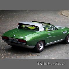 a green car parked on top of a parking lot