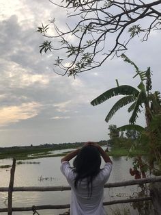 a woman is looking out over the water