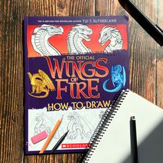 the official wings of fire how to draw book with pencils and markers on wooden surface