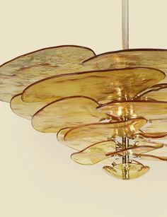 a chandelier made out of blown glass with gold leaf designs hanging from the ceiling