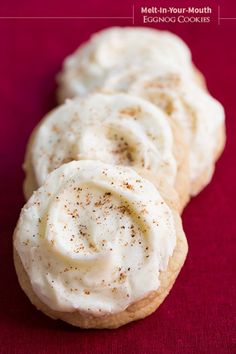 cinnamon rolls with cream cheese frosting on a red surface