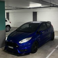 a blue car parked in a parking garage