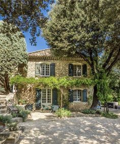 an old stone house surrounded by trees